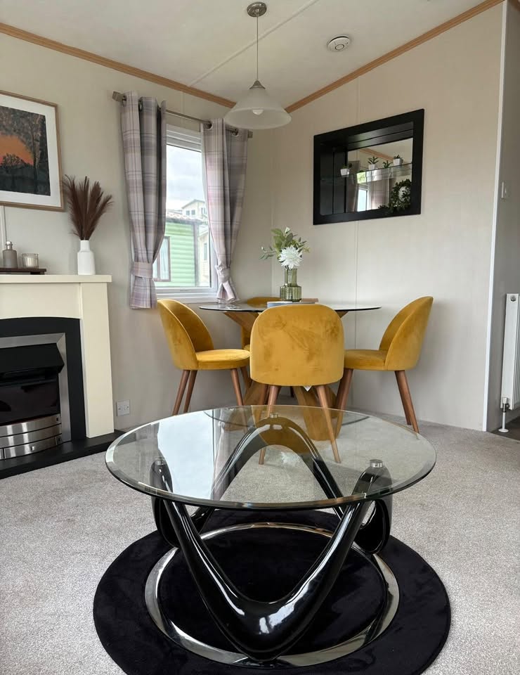 Living and dining area with fireplace and mustard velvet dining chairs