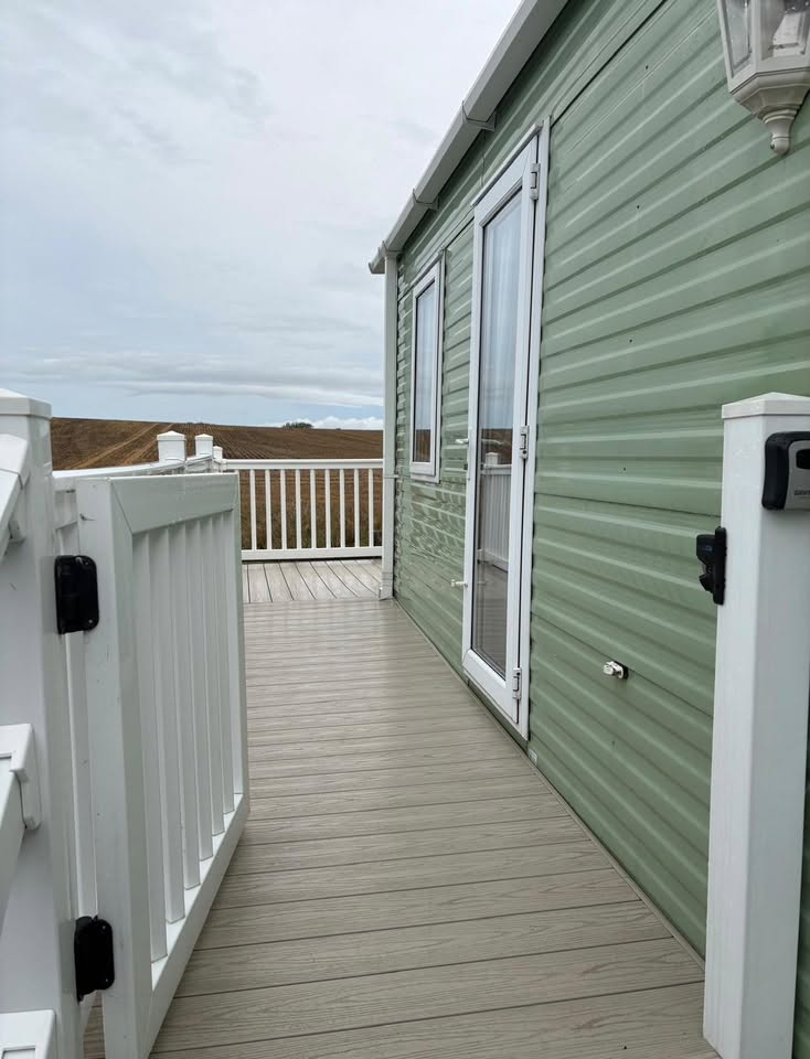 Private decking running alongside the caravan with fields beyond